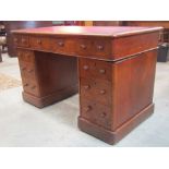 A Victorian oak kneehole twin pedestal writing desk, with inset faux leather panel top over the