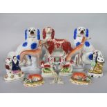 A collection of 19th century Staffordshire models of dogs comprising a standing spaniel with rust