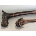 A 19th century rustic walking stick, the head with carved mount showing character in peaked cap