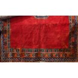 Kurdish type full pile carpet with a central blue medallion and borders upon a red ground, 340 x 240