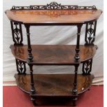 A mid Victorian period figured walnut three tier whatnot with shaped outline marquetry inlay and