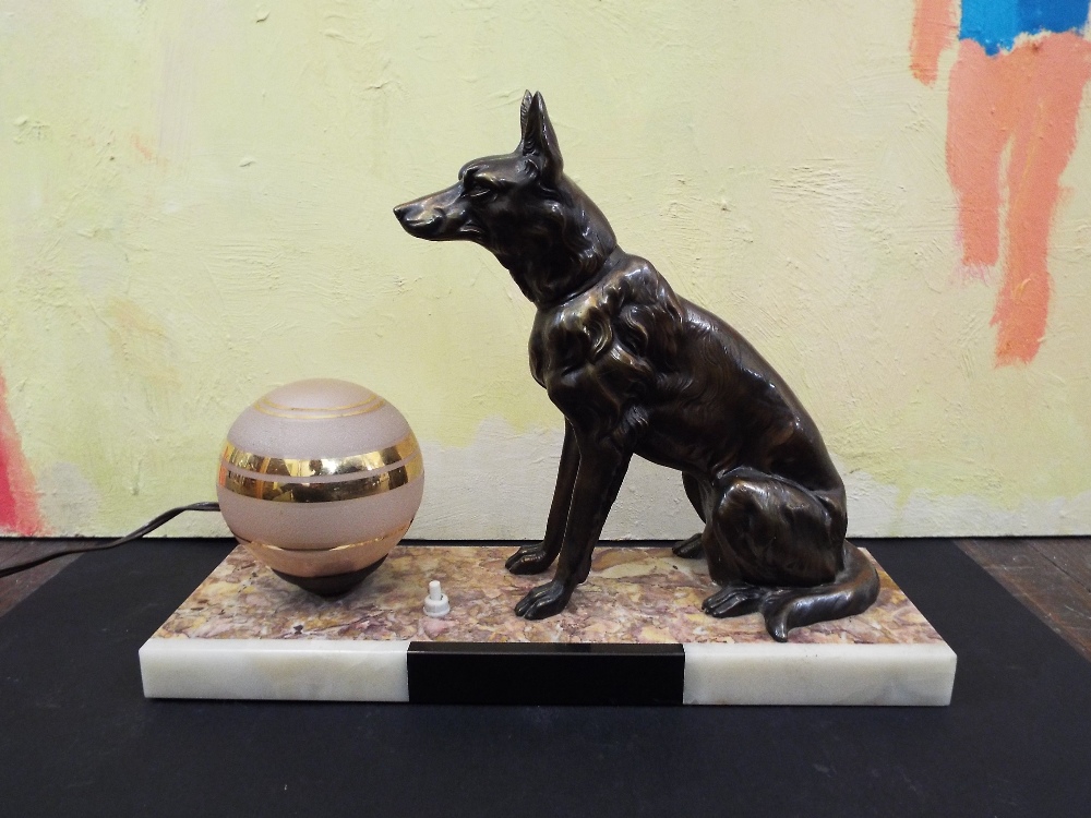 Art Deco figural lamp in the form of an Alsatian next to a pink shade with gilt highlights, upon a