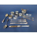 A collection of various silver items to include five napkin rings,, cream jug, two sugar nips, two