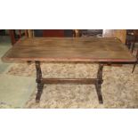 A stained elm refectory table (possibly Ercol or Priory) of rectangular form, with rounded