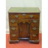 A small 18th century kneehole writing desk with inset leather top, the front elevation enclosed by a