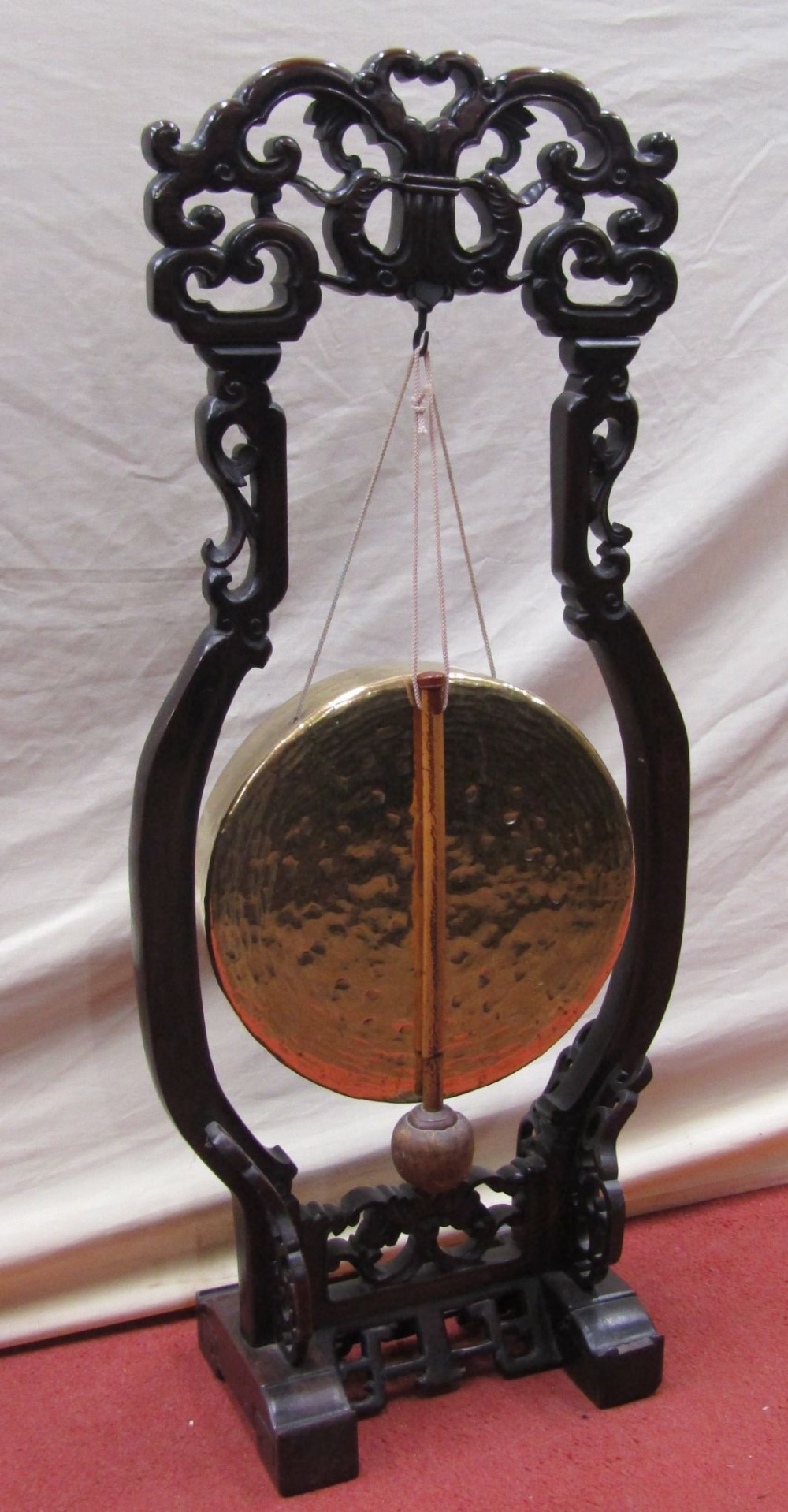 A brass house gong and strike, set within a carved 19th century Chinese hardwood floor standing