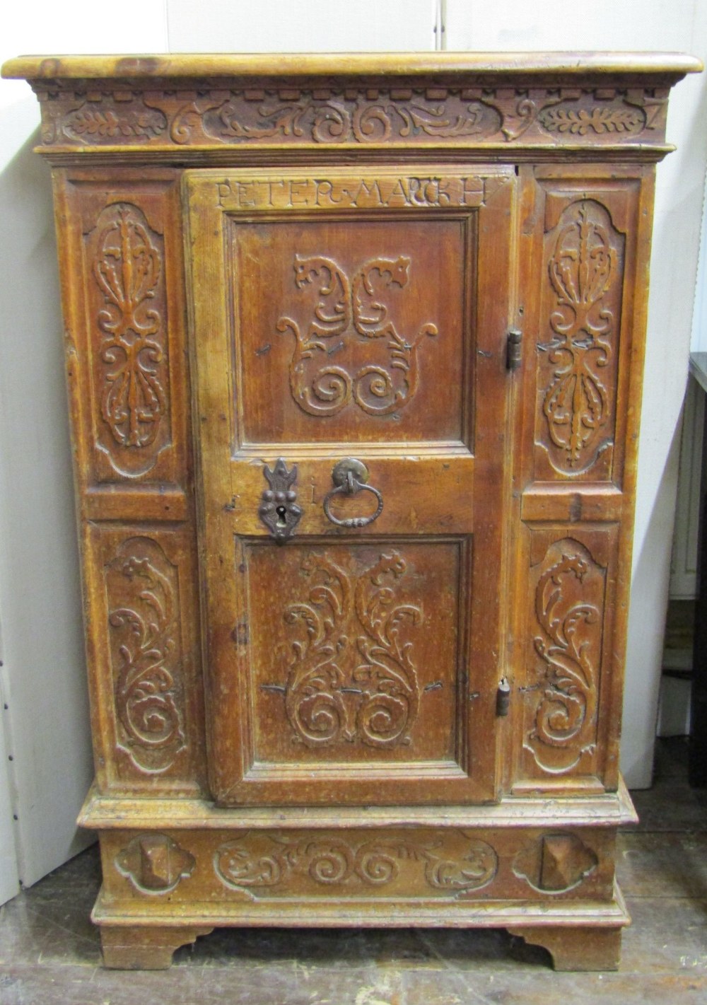 A 17th century pine side cupboard of continental origin, the central door with ironwork fittings,