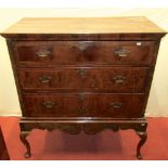 A Georgian walnut chest on stand, the upper section fitted with three long drawers, with crossbanded