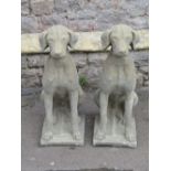 A pair of contemporary cast composition stone garden ornaments in the form of seated hounds,