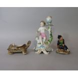 A candlestick in the 18th century Chelsea manner with applied figure of a cherub and floral garland,