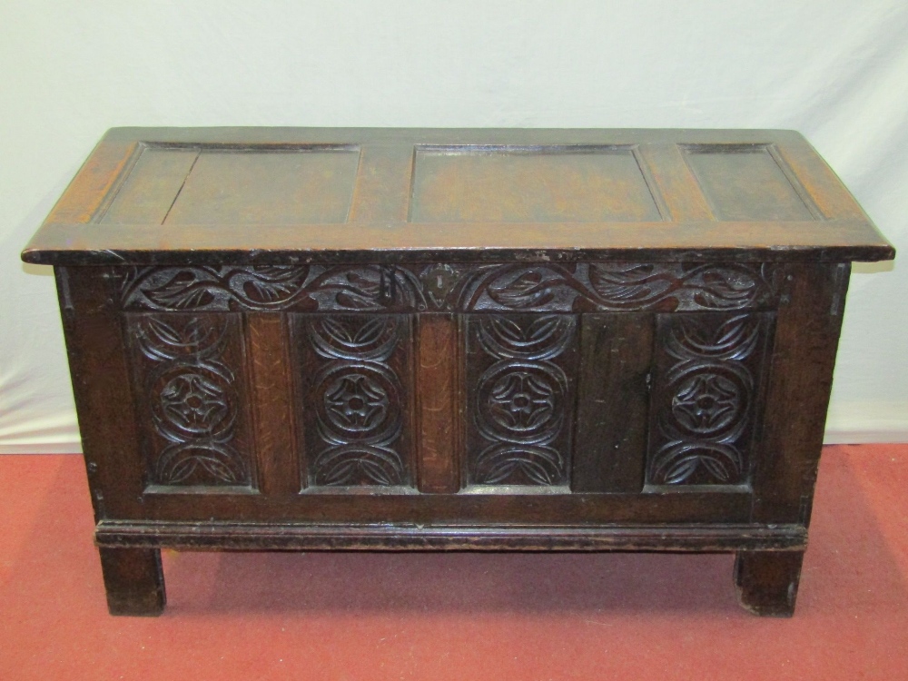 An 18th century oak panelled coffer, the front elevation with repeating Tudor rose and floral