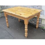 A Victorian style stripped pine kitchen table of rectangular form, with moulded outline, raised on