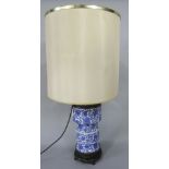 A late 19th century blue and white printed two sectional ceramic lamp base, with stylised floral