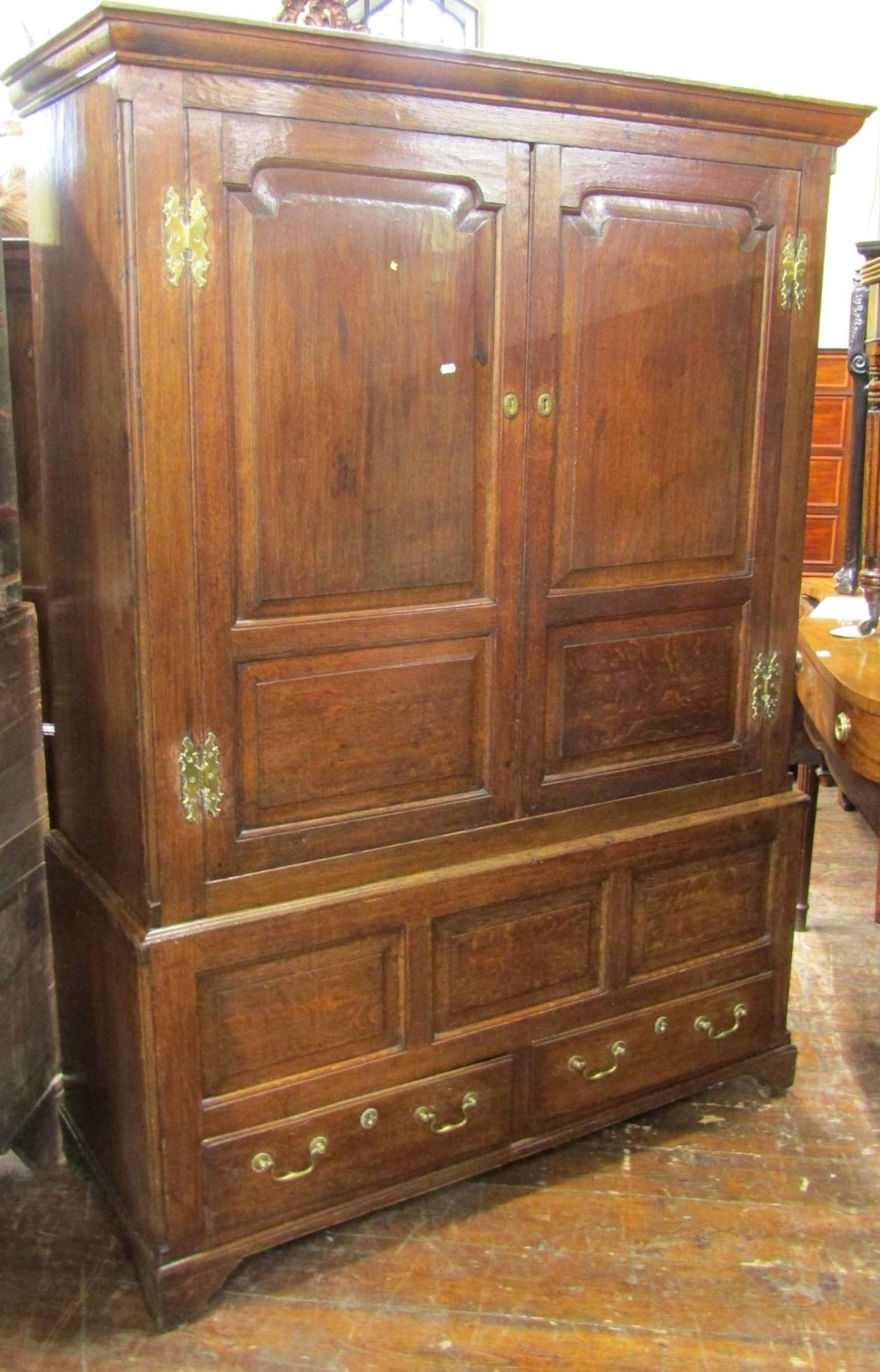 A Georgian oak livery cupboard, the upper section enclosed by a pair of panelled doors with