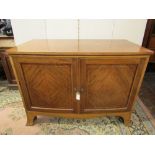 An Edwardian mahogany bow fronted side cupboard enclosed by two panelled doors, on swept supports,