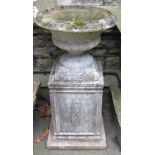 A weathered cast composition stone garden urn, the squat circular bowl with flared rim and lobed