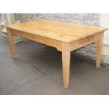 A stripped pine farmhouse kitchen table of rectangular form with tongue and groove plank top, over