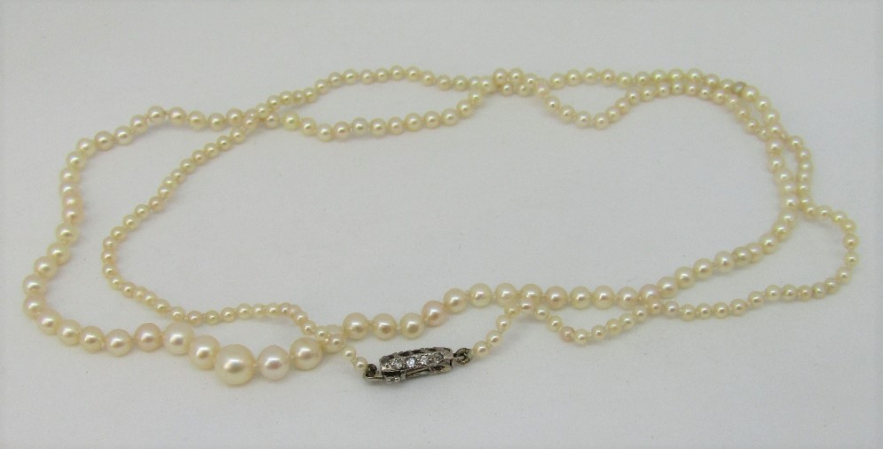 Antique single strand graduated pearl necklace, the white metal clasp set with diamond chips, 53.5cm