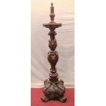 A substantial oak torchere, the column of shaped form, fully carved with acanthus and other