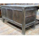 An 18th century oak coffer, with panelled framework and repeating geometric detail, raised on