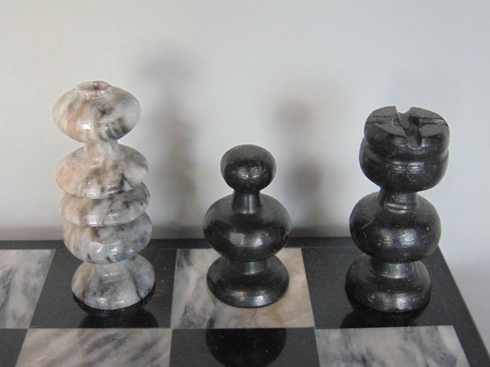 Carved hardstone chess set within a marble chequerboard games board - Image 2 of 2