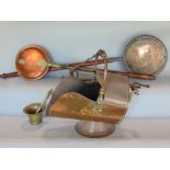 A 19th century copper helmet shaped coal scuttle, two copper warming pans, a set of 19th century