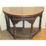 A good early oak credence table, the D end top raised on four gun barrel shaped pillars with