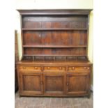 An 18th century oak dresser, the lower section enclosed by three panelled doors and three frieze