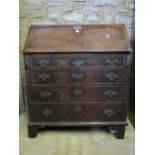 A Georgian mahogany bureau, the fall flap enclosing a fitted interior of drawers and pigeon holes