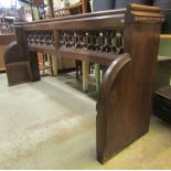 A 19th century oak church pew with shaped and chamfered ends beneath a moulded rail, pierced