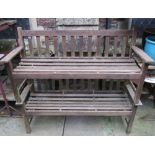 A pair of weathered teak three seat garden benches with slatted seats and backs, probably Lister