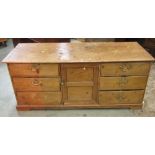 A low antique stripped and waxed pine dresser, partially enclosed by a central twin moulded panel