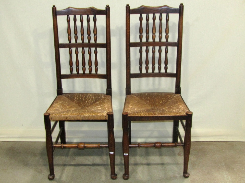 A set of four Lancashire style spindle back dining chairs with rush seats and simple turned