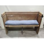An old pine church pew with moulded rail, plank seat and panelled back, 146 cm long