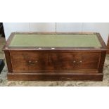 A low mahogany table, with inset leather panel top over a long drawer and moulded plinth, together