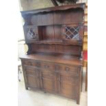 A reproduction oak dresser, possibly JC or Old Charm, the base enclosed by three panelled doors