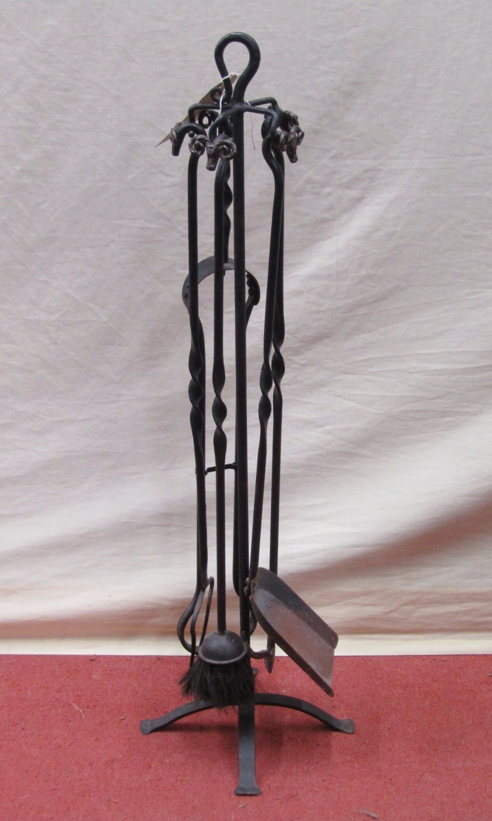 An iron work floorstanding companion set with rams head detail