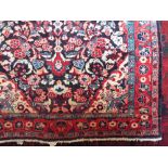 Persian full pile rug decorated with various floral sprays upon a navy blue ground, 210 x 130 cm