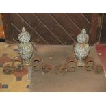 A pair of antique andirons with cast brass baluster shaped stems/finials with repeating mask and