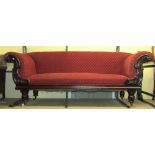 A late Regency/William IV mahogany scroll end sofa with carved and applied detail raised on carved