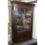A 19th century mahogany hanging corner cupboard, the single door partially glazed over a panelled