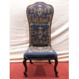 A Victorian rosewood nursing chair raised on cabriole supports with later hand worked tapestry