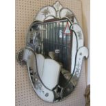 A Venetian style shield shape wall mirror with segmented foliate surround, 77cm high x 62cm wide