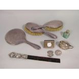 A box containing a collection of various silver to include two dressing brushes and mirror, a silver