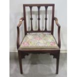 A Georgian mahogany open elbow chair, with shaped foliate vertical splats over a floral tapestry