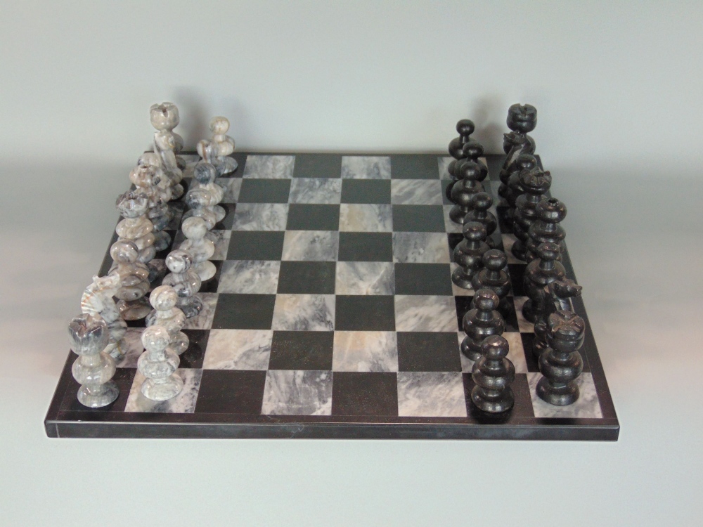 Carved hardstone chess set within a marble chequerboard games board