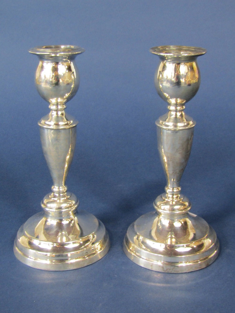 Pair of 1920s silver baluster candlesticks upon stepped circular bases, maker marks rubbed, London