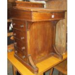 A Victorian walnut veneered davenport fitted with the usual arrangement of real and dummy drawers,