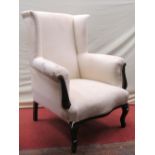 An Edwardian wing back chair with partial show wood frame raised on cabriole supports - for final