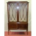 A good quality Edwardian display cabinet enclosed by a pair of lattice work doors over two